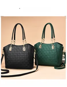 Detail of embossed dot texture on black and green PU leather tote bags with gold chains