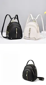 Detail of mini faux leather backpacks in black and beige with gold zipper hardware