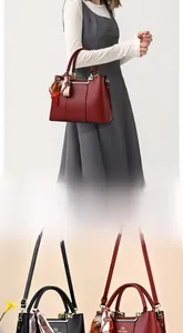 Detail of red and black textured leather tote bag with silk scarf and gold hardware