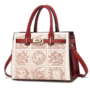 Elegant off-white handbag with red leather trim and detailed floral embroidery