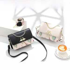 Detalle de bolsos cuadrados pequeños con cierres de cisne y estampados de la Torre Eiffel