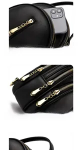 Detail of black pebbled leather mini backpack with three golden zippers and front pocket