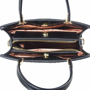 Interior view of black leather handbag showing multiple compartments and golden zipper