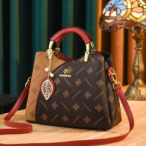Vintage patterned handbag in contrast brown leather with red handles and gold charms