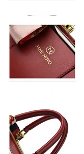Close-up of red pebbled leather tote with golden logo and decorative silk scarf detail