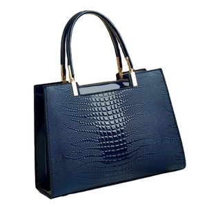 Glossy navy blue crocodile pattern handbag with sturdy handles and gold metal accents