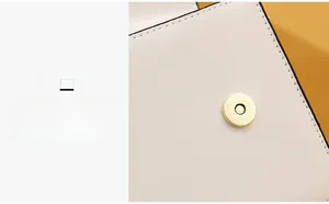 Detailed close-up of the light gold magnetic snap closure on a white leather crossbody bag
