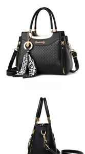 Close-up of black quilted leather handbag with gold hardware and leopard print charm