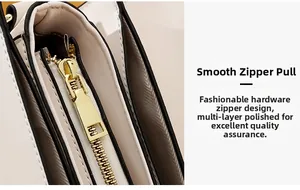 Detailed close-up of the smooth gold-tone zipper and polished hardware on the white bag