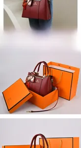 Deep red leather handbag with silk scarf and matching luxury orange gift box and shopping bag