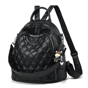 Quilted black backpack with a cute cow plush pendant and front zipper pocket