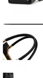 Detail view of black leather handbag bottom with metal studs and golden frame structure