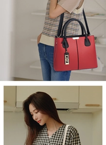 Vue détaillée du sac à main rouge grainé avec bandoulière noire et détails dorés