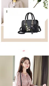 Detail of floral embroidery and butterfly charm on a black leather handbag
