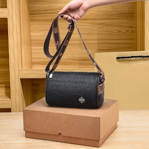 Black crocodile pattern cylinder bag with vintage patterned strap and silver clover logo