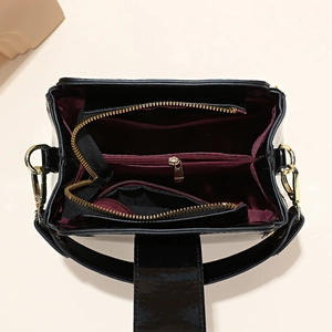 Glossy black patent leather bucket bag with red lining and spacious compartments