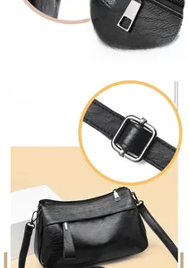 Detail of glossy metal zipper and adjustable strap buckle on black textured leather bag