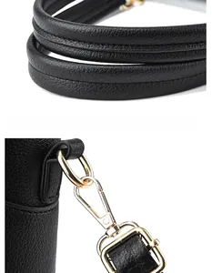 Close-up of black leather tote bag featuring golden metal hooks and durable stitching