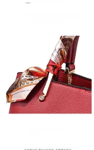 Detail of red lychee grain leather bag with floral silk scarf and rhinestone buckle