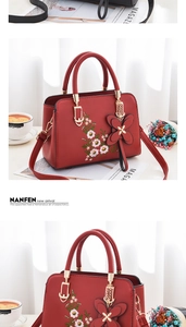 Close-up of red leather handbag with exquisite flower embroidery and gold butterfly charm
