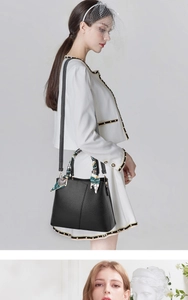 Detail view of black pebble leather tote with decorative silk scarf and fine stitching