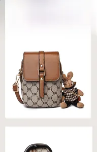 Détail du rabat en cuir marron avec monogramme MFX et breloque lapin sur le mini sac