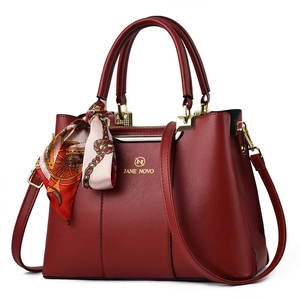 Dark red leather tote bag for women with gold hardware and decorative floral scarf detail