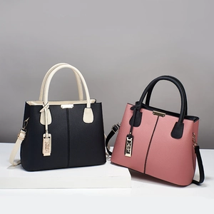 Sac à main élégant en cuir bicolore noir et rose avec des détails en métal doré