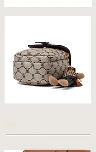 Détail du sac bandoulière multicouche avec imprimé monogramme rétro et breloque ourson