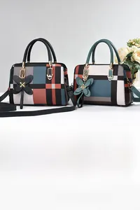 Detailansicht von Vintage-Karo-Handtaschen mit Schmetterlingsanhängern und Trageriemen