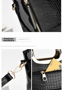 Close-up of crocodile pattern black patent leather bag with textured golden hardware