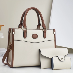 Detailed set of three beige tote bags with brown handles and gold hardware details