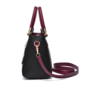 Sac à main élégant en cuir bicolore noir et bordeaux avec ferrures dorées et fermetures éclair