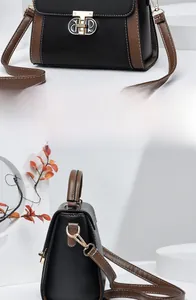 Dettaglio borsa retrò bicolore con fibbia ad anello dorata e cuciture bianche a vista