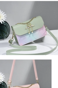 Close-up of elegant swan metal clasp and pearl tassel on colorful PU leather small bags