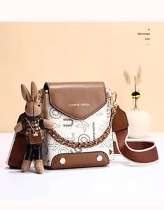 Detail of a chic crossbody phone bag with chain strap and cute rabbit doll charm