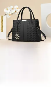 Detailed view of black litchi leather handbag with woven texture and heart charm