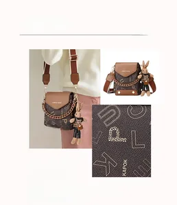 Detail view of brown patterned crossbody bag with metal chain and cute rabbit charm