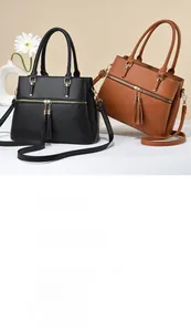 Detail of high-quality pebbled leather handbags with tassel charms in black and brown