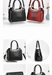Detail view of glossy crocodile texture handbag with gold U-shaped handle and side zipper