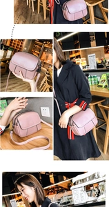Detail view of pink lychee leather crossbody bag with three zip compartments and strap