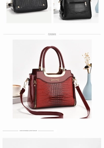 Detail of red embossed crocodile pattern texture and gold hardware on lady handbag