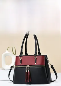 Detail of color-block tote with lychee grain texture and elegant tassel zippers