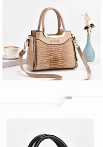 Detail of beige crocodile embossed leather handbag with metal handle and shoulder strap