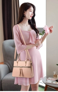 Close-up of pink beige tote bag featuring litchi grain leather and gold tassel detail