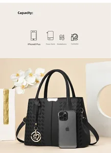 Detail showing capacity of black soft leather handbag with embroidered pattern.