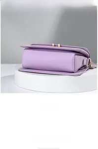 Detail view of the purple crossbody bag bottom and base with elegant pearl buckle