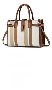 Close-up of canvas tote bag showing striped pattern and brown leather straps