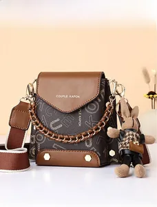 Brown monogram crossbody bag with shoulder strap, metal chain and rabbit charm