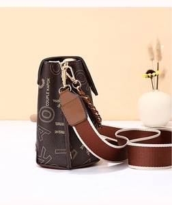 Detail of brown leather crossbody bag with letter print and gold chain strap accent